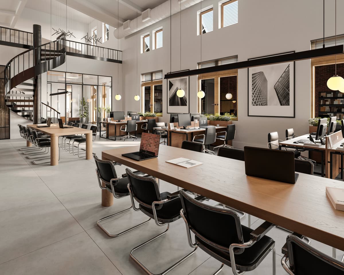 Double-height coworking floor with long timber desks and a spiral stair